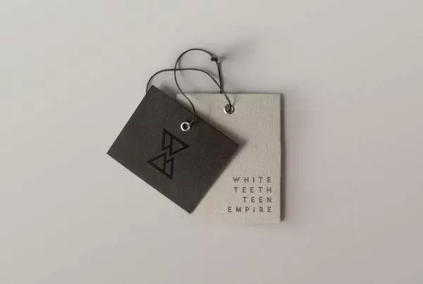 Picture of a clothes brand label in black and beige with white teeth teen empire logo